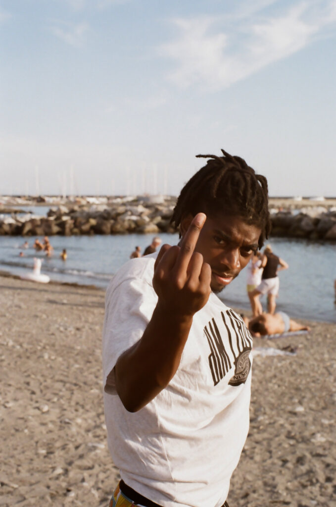 Un jeune homme faisant un doigts d'honneur au photographe avec un sourire taquin.