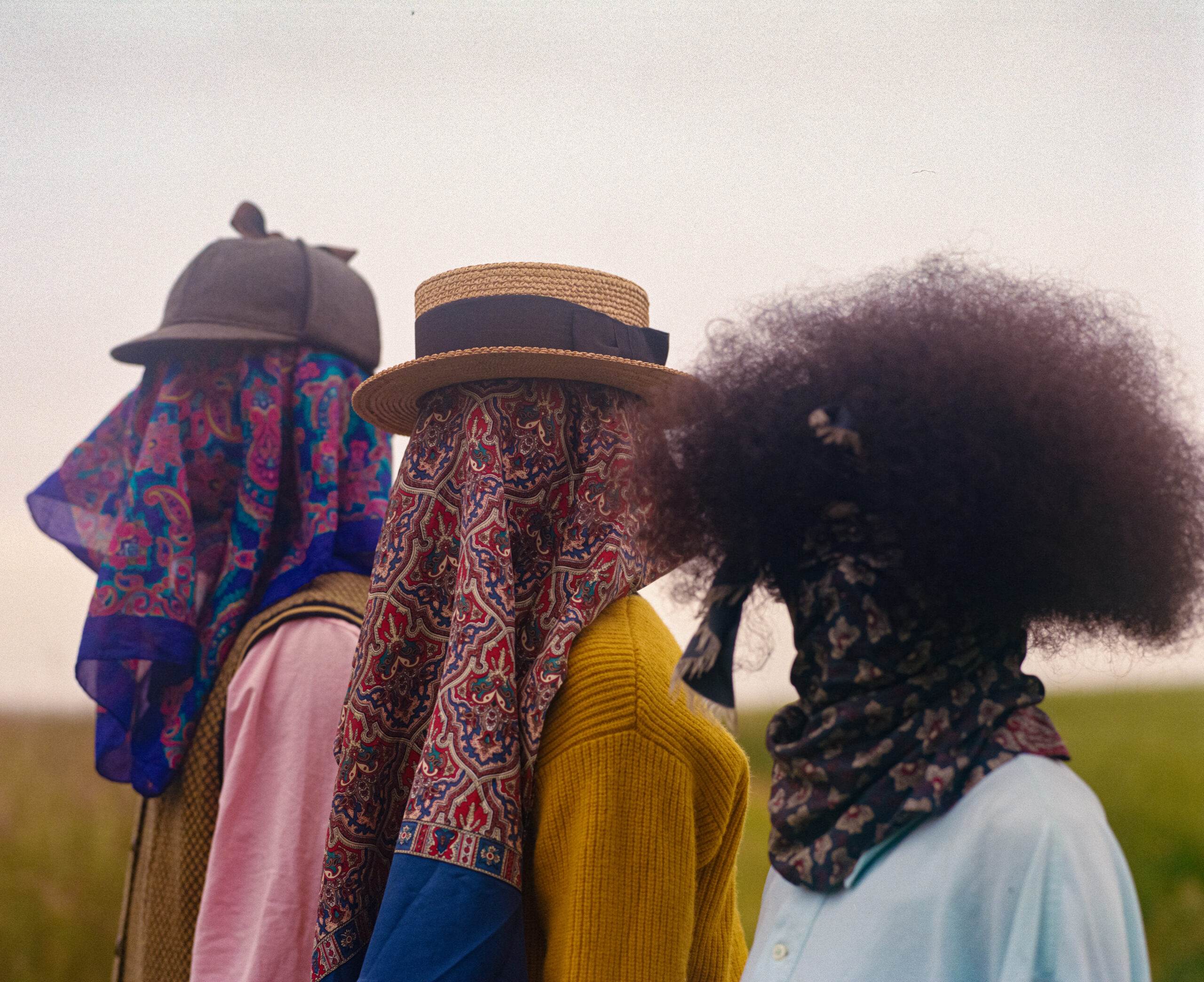 Trois personne avec le visage caché par un tissu 